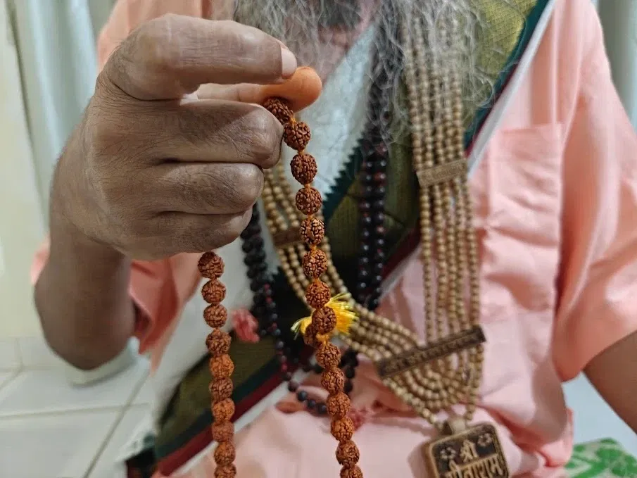 Shri Damodar Dasji Maharaj using the Rudraksha Mala for mantra chanting